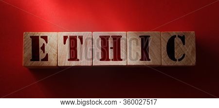 Ethic Word On Wooden Cubes On Red Background. Codex Of Ethics And Morel Concept