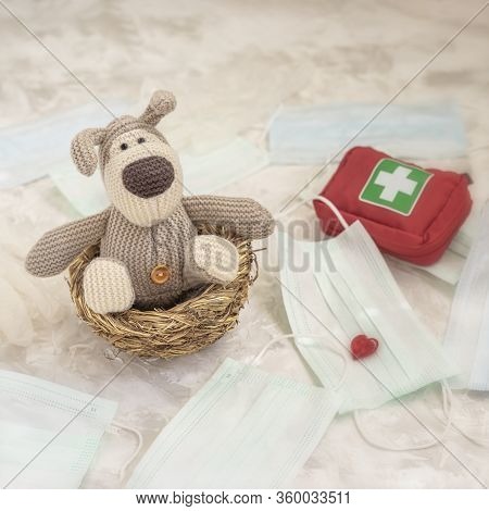 Toy Puppy Self-insulated In A Nest Among Medical Masks And An Individual First-aid Kit, Health Care 