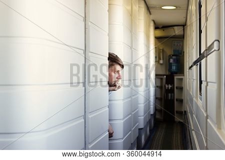 Handsome Young Caucasian Man With A Beard, Hand To Cheek, Looks Outside Of The Train's Window, Looki