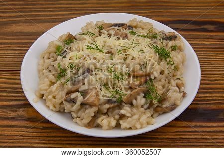 Tasty Appetizing Risotto On A White Plate On A Wooden Table