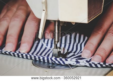Woman Hands Using The Sewing Machine To Sew A Colorful Face Medical Mask During The Coronavirus Pand