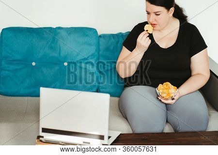 Mindless Snacking, Home Sedentary Lifestyle, Compulsive Overeating. Obese Lazy Woman Sitting On Sofa