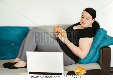 Mindless Snacking, Home Sedentary Lifestyle, Compulsive Overeating. Obese Lazy Woman Sitting On Sofa