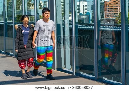 Melbourne Australia - March 10 2019; Asian Tourist Couple On Sandridge Pedestrian Bridge Passing The