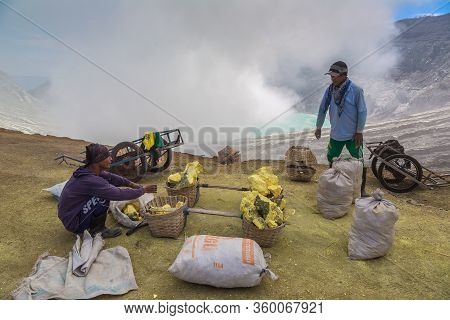 East Java, Indonesia - February 27, 2020: Miner Extracting Sulfur Inside The Crater Of Active Volcan