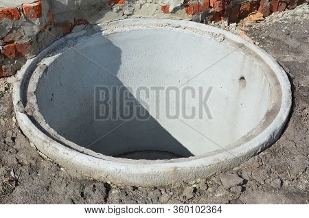 Installation Of A Water Main Sewer And Drain. A Close-up On A Concrete Sewer Well, Ring In The Groun