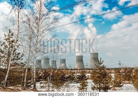 Six Biton Tubes Of A Nuclear Power Plant Against A Cloudy Blue Sky.
