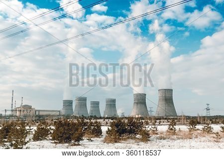 Six Biton Tubes Of A Nuclear Power Plant Against A Cloudy Blue Sky.