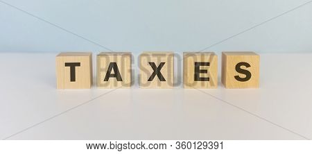Word Tax. Wooden Small Cubes With Letters Isolated On Blue Background With Copy Space Available.busi