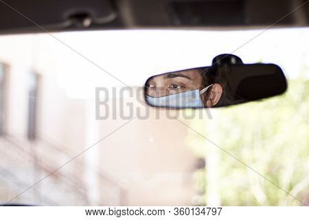 A Young Woman In A Surgical Face Mask And Gloves Driving The Car During Coronavirus Pandemic. A Fema