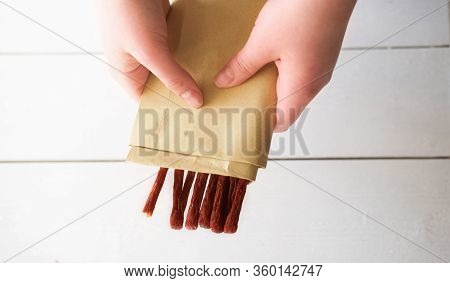 Womans Hand Holding Biltong Or Jerked Meat. Traditional South African Dried Meat . Biltong Strips In