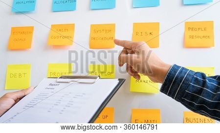 Young Business Workers Posting With Sticky Notes Stickers Reminders  Creative Brainstorming At Board