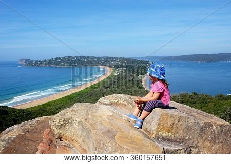 A Little Baby Girl Admiring A View Of The Scenic Landscape Of The Palm Beach In Sydney, Australia
