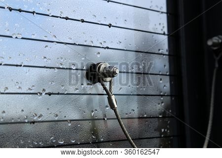 Glass Fixed With A Metal Cable And Bolt With Nut