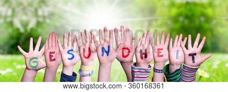 Kids Hands Holding Word Gesundheit Means Health, Grass Meadow