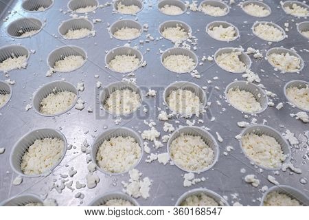 Stage in production of cheese - Forming pressing of cheese mass. Cheese grains about 6 mm in size in
