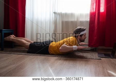 Man Doing Backbend Salabhasana, Locust Pose, Double Leg Kicks At The Living Room