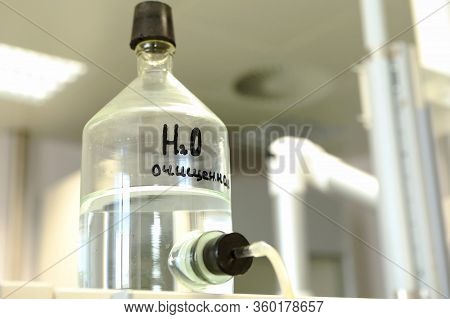 Conducting A Chemical Experiment In A Laboratory. Colored Flasks With Chemical Reagents. Many Glass 