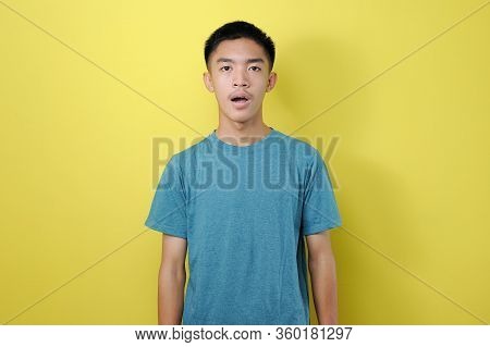 Portrait Of Dumbfounded Young Asian Man Look At Camera, His Mouth Open, Silent Expectation Of Observ