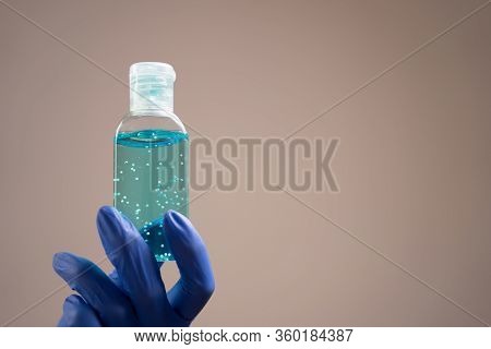 Treatment Of Hands With An Antiseptic Gel. Side View Of Hands In Rubber Gloves With Alcohol Gel On A