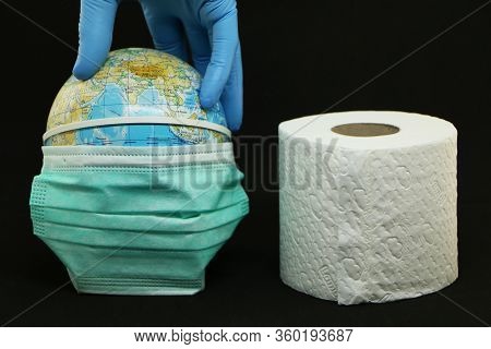 Close-up - A Medical Mask Is Dressed On Planet Earth. A Hand In A Blue Rubber Glove Twists The Plane
