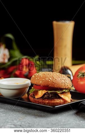 Burger With Cutlet, Cheese And Tomatoes. With French Fries And Burger Sauce