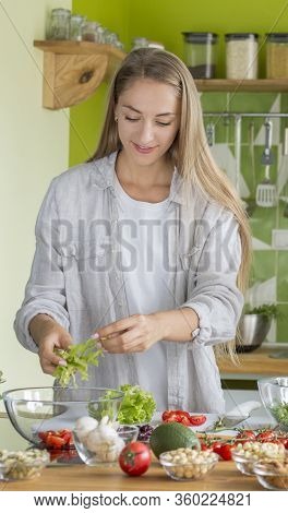Young Attractive Woman Cooking Fresh Salad In The Kitchen For Lunch Break, Vertical Panorama