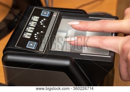 The Process Of Scanning Fingerprints During The Check At Border Crossing. Female Hand Puts Fingers T