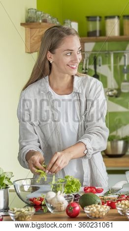 Attractive Woman Cooking Fresh Vitamin Salad In The Kitchen At Home, Vertical Panorama