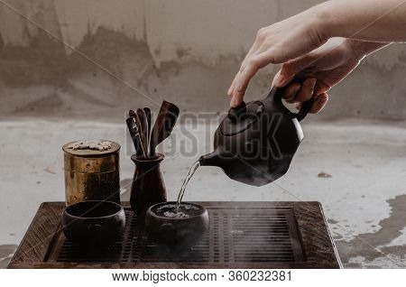 Cropped Shot Of Woman Pouring Tea In Traditional Chinese Teaware