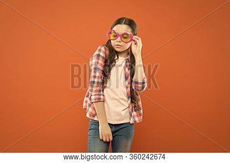 Fashionable Cutie. Being Smart. Little Smart Schoolgirl On Orange Background. Child Smart Look Throu