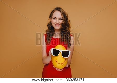 Beautiful Young Girl Holds Hands Melon. The Melon Is Wearing Glasses And An Emoticon Is Drawn. Girl 