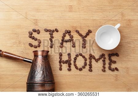 The Slogan Stay Home As Inscription Lined With Roasted Coffee Beans On A Homemade Wooden Cutting Boa