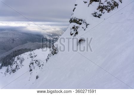 Snowboarder Is Riding Down The Snowy Slopes During A Cloudy Day. Taken In Revelstoke Ski Resort, Bri