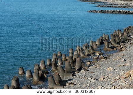 Tetrapod Breakwaters On The Coast. Concrete Breakwaters Of Tetrapods Lie All Along The Coast.