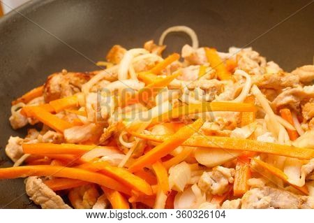 Onions, Carrots And Meat Are Fried In A Non-stick Pan. Appetizing Fried Carrots With Onions And Meat
