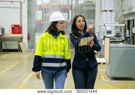 Female Plant Manager With Tablet And Inspector Monitoring Production Process Onsite. Middle Aged Wom