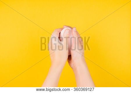 Washing Hands With Soap Under Colorful Yellow Background Top View. Coronavirus Prevention And Person