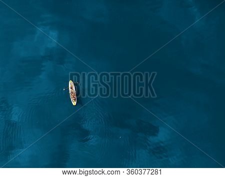 Aerial Drone View Of Family Having Fun Swimming On Sup Stand Up Paddle Inflatable Surf Board. Mother
