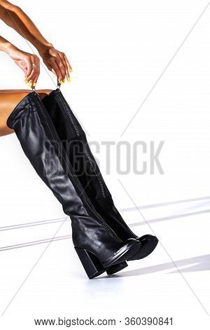 Black Hessian Boots On The Feet Of A Model On A White Background With Shadows. Jackboots. Studio Sho