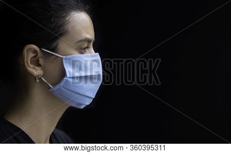 Worried Young Woman Wearing Medical Face Mask, Studio Portrait. Woman Wearing Face Mask During Coron