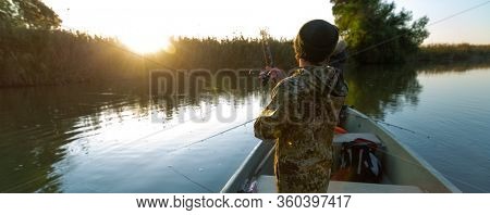 Anglers fishing from the boat on the calm river in Astrakhan Region in Russia. Astrakhan is a famous fishing destination
