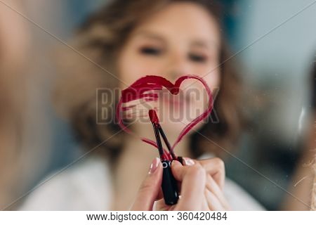 Woman Painting A Heart On The Mirror With A Red Pomade