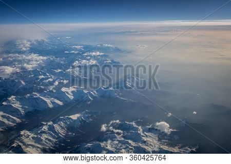 View from a cockpit of a commercial airliner airplane over a beautiful mountain range
