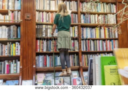 Many Different Books On The Shelves In The Store. Blurred. Background.