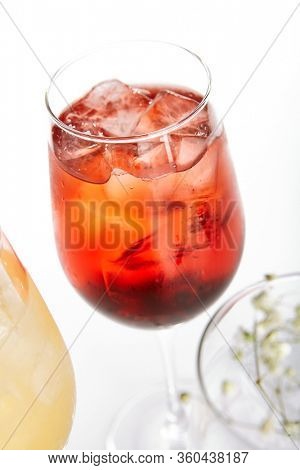 Rose Spritz cocktail. Alcohol soft drinks in glasses side view. Refreshment beverage with rose lemonade in drinkware. Exotic summer beach cocktail portions with crushed ice in glassware