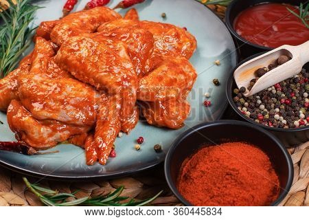 Marinated Chicken Wings In A Blue Dark Plate With Tomatoes And Spices.grilled Chicken Wings Recipe.