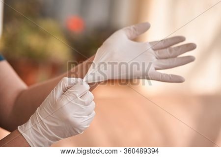 Female Surgeon Or Nurse Wearing A Sterile Suit Putting On Sterile Rubber Gloves To Perform A Surgery
