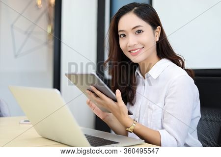 Asian Business Women Using Tablet  For Working At Office Relax Time And Smiling