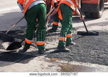 Workers On Asphalting Paver Machine During Road Street Repairing Works. Street Resurfacing. Fresh As